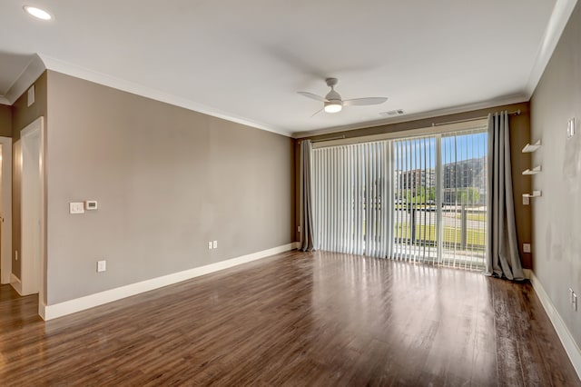 empty room with dark wood-type flooring, ceiling fan, ornamental molding, and baseboards