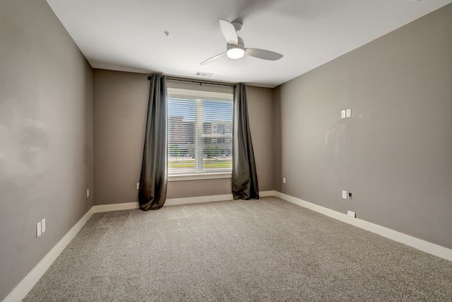 empty room featuring baseboards, visible vents, light carpet, and a ceiling fan