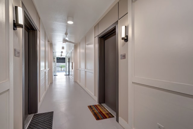 hall featuring finished concrete flooring and elevator