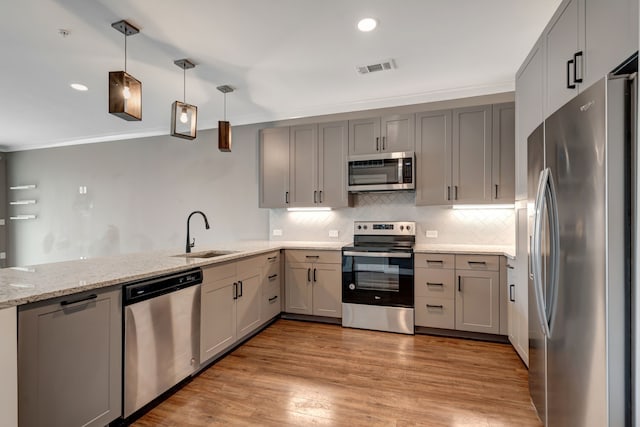 kitchen featuring a sink, appliances with stainless steel finishes, visible vents, gray cabinetry, and light stone countertops