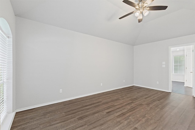 spare room featuring ceiling fan, vaulted ceiling, dark wood-style floors, and baseboards