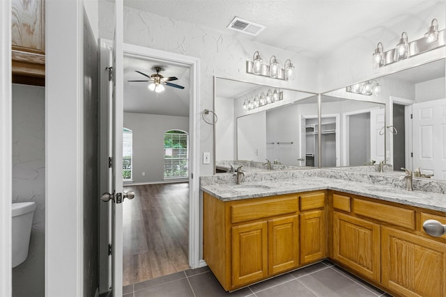 bathroom featuring visible vents, a sink, a ceiling fan, and double vanity