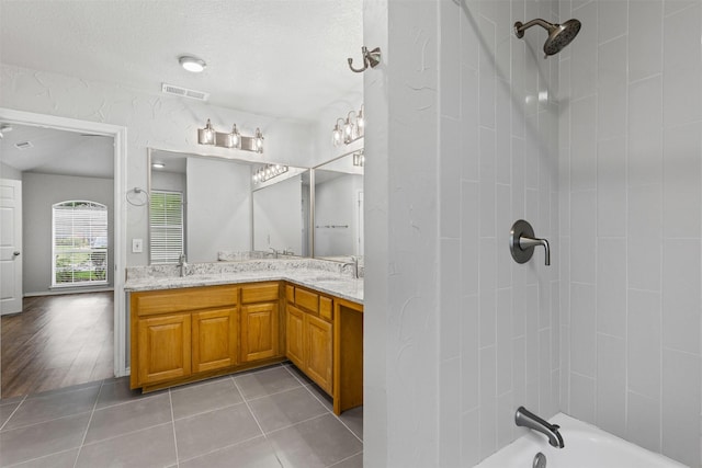 full bathroom featuring a sink, double vanity, tile patterned floors, shower / washtub combination, and visible vents