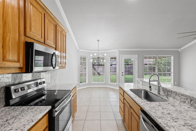 kitchen with crown molding, an inviting chandelier, a sink, appliances with stainless steel finishes, and light tile patterned floors