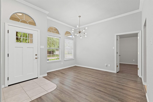 entrance foyer with crown molding, baseboards, wood finished floors, and an inviting chandelier