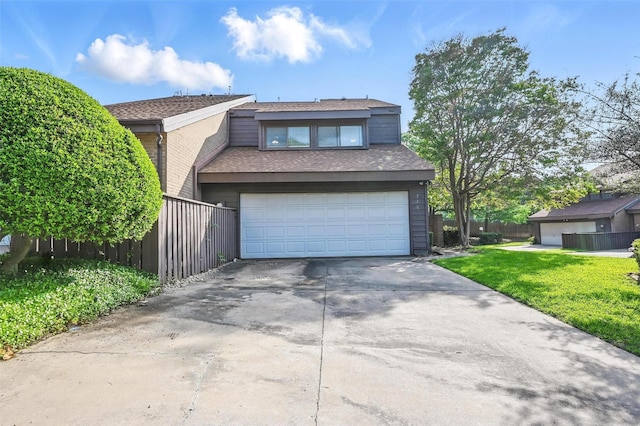 view of front of property with fence, a front lawn, driveway, and an attached garage