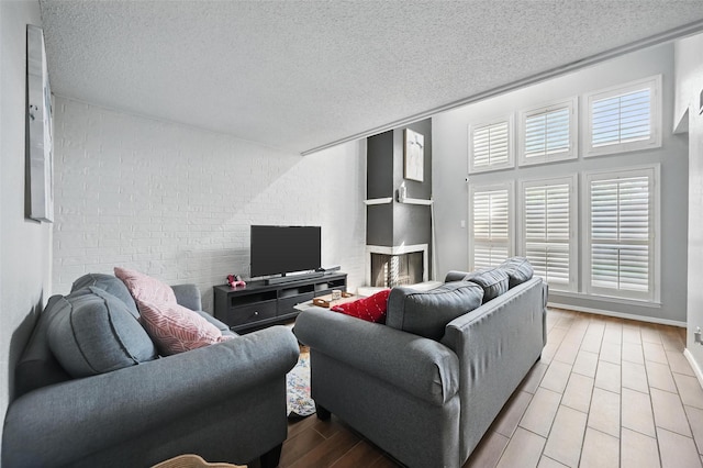 living room featuring a textured ceiling, wood finished floors, and baseboards