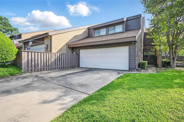 view of front facade with a front yard, a garage, driveway, brick siding, and fence