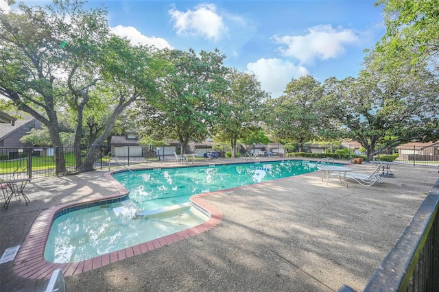 community pool with fence and a patio