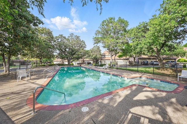 community pool featuring fence and a patio area