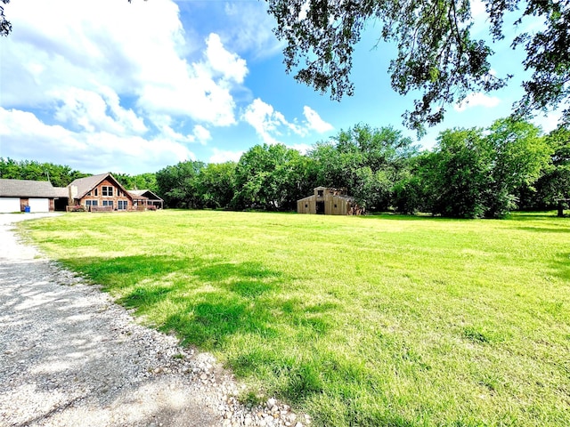 11300 Massey Rd, Pilot Point, TX 76258 - view of green lawn with driveway, an outdoor structure, and a view of rural / pastoral area