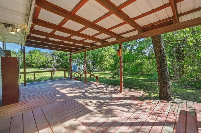 wooden terrace with a storage shed, an outbuilding, and a lawn