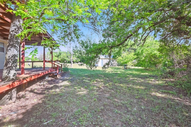 view of yard featuring an outdoor structure and a wooden deck