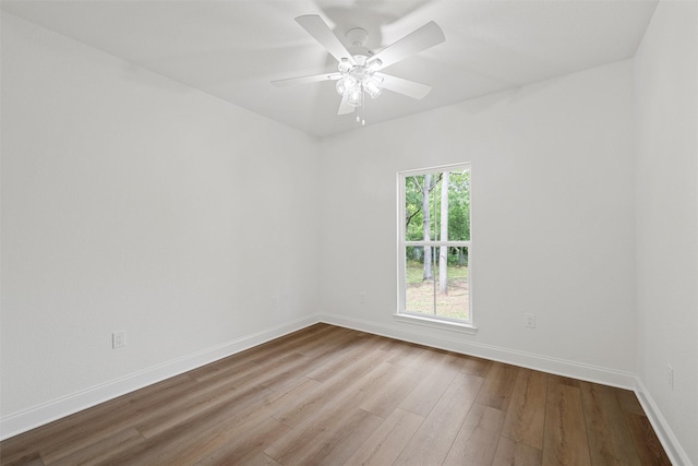 unfurnished room with baseboards, wood finished floors, and ceiling fan