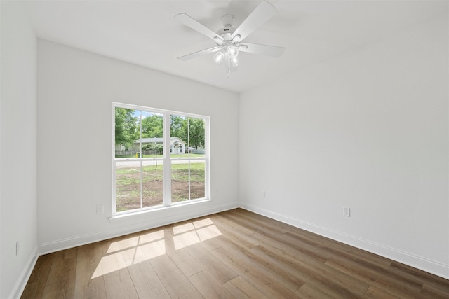 spare room with ceiling fan, wood finished floors, and baseboards
