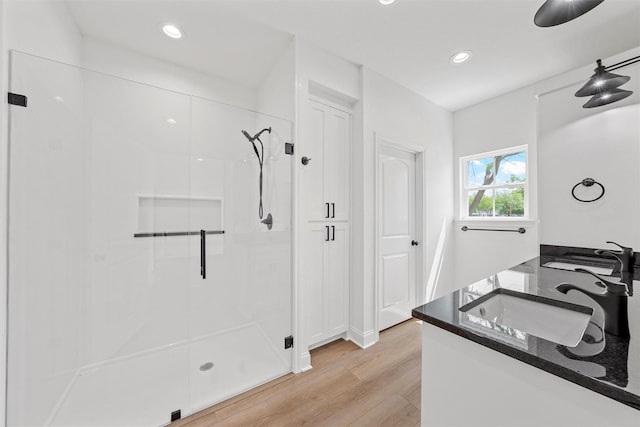 bathroom with wood finished floors, vanity, recessed lighting, and a stall shower