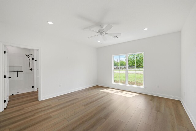 spare room featuring visible vents, ceiling fan, light wood-style flooring, and baseboards