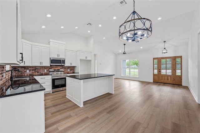 kitchen with dark countertops, visible vents, appliances with stainless steel finishes, and ceiling fan with notable chandelier