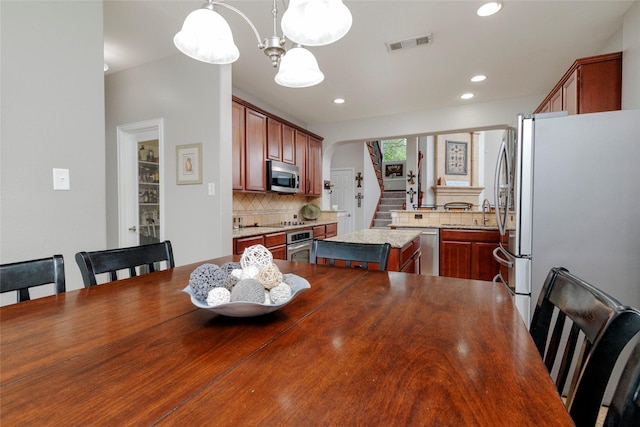4953 Van Zandt Dr, Fort Worth, TX 76244 - dining room with recessed lighting, arched walkways, stairway, a chandelier, and visible vents
