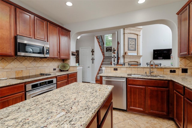 4953 Van Zandt Dr, Fort Worth, TX 76244 - kitchen featuring recessed lighting, arched walkways, a sink, and appliances with stainless steel finishes