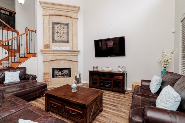 4953 Van Zandt Dr, Fort Worth, TX 76244 - living area featuring a high end fireplace, light wood finished floors, stairs, and baseboards