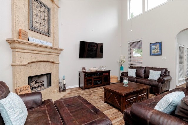4953 Van Zandt Dr, Fort Worth, TX 76244 - living room with arched walkways, a healthy amount of sunlight, a high ceiling, and wood finished floors