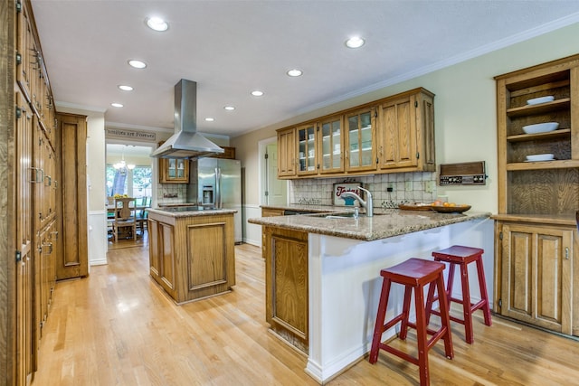7215 Hillwood Ln, Dallas, TX 75248 - kitchen with island range hood, stainless steel fridge with ice dispenser, brown cabinets, a kitchen island, and recessed lighting