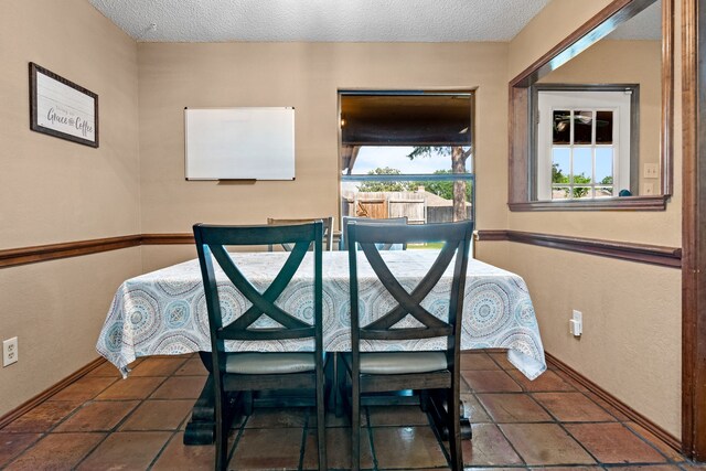 dining area featuring baseboards and a textured ceiling