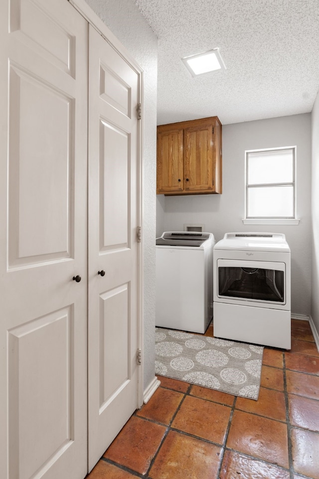 laundry area featuring cabinet space, a textured ceiling, and washer and dryer