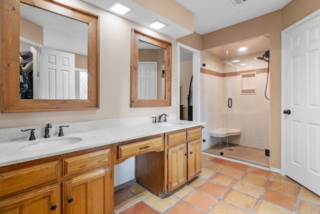 full bathroom with a sink, tile patterned floors, a stall shower, and double vanity
