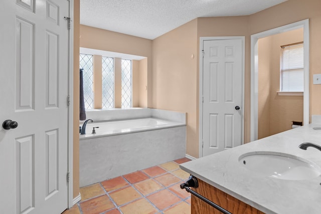 bathroom featuring a sink, double vanity, a textured ceiling, tile patterned floors, and a garden tub