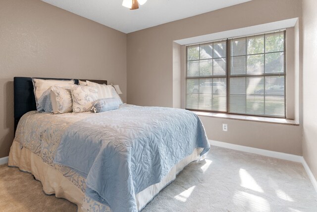 bedroom with baseboards, light carpet, and a ceiling fan