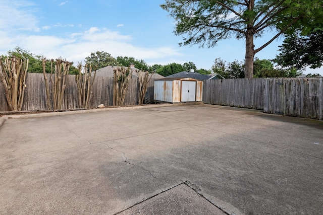 view of patio / terrace featuring an outbuilding, a fenced backyard, and a storage unit