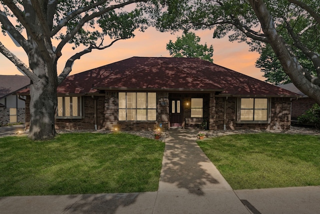 view of front of property with a yard and brick siding