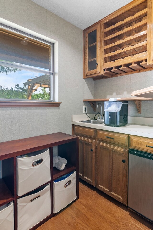 kitchen featuring a sink, glass insert cabinets, and light wood-style floors