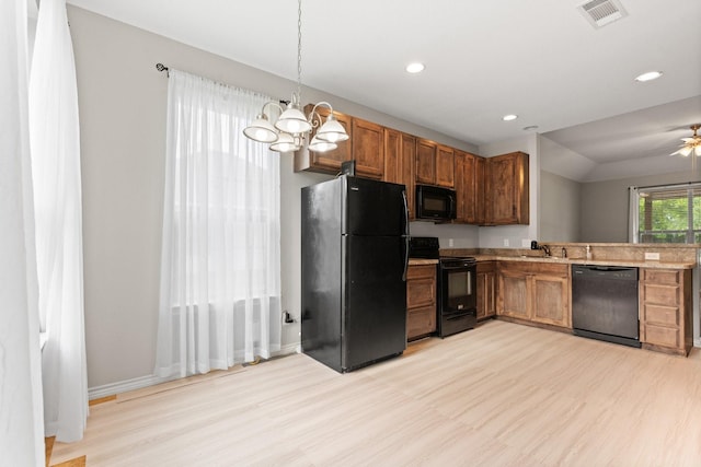305 S 1st St, Grandview, TX 76050 - kitchen with visible vents, a sink, light wood finished floors, and black appliances