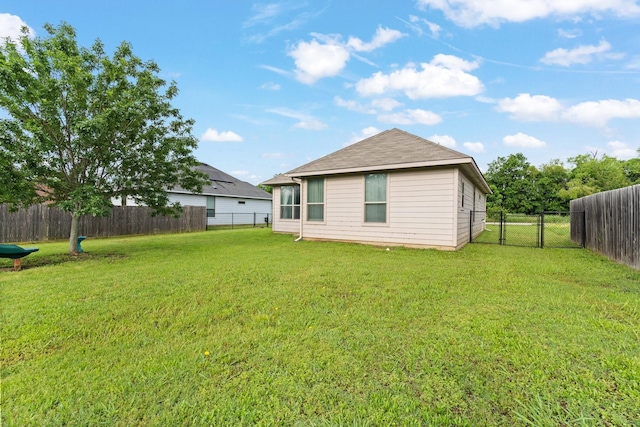 305 S 1st St, Grandview, TX 76050 - back of house featuring a lawn, a gate, and a fenced backyard