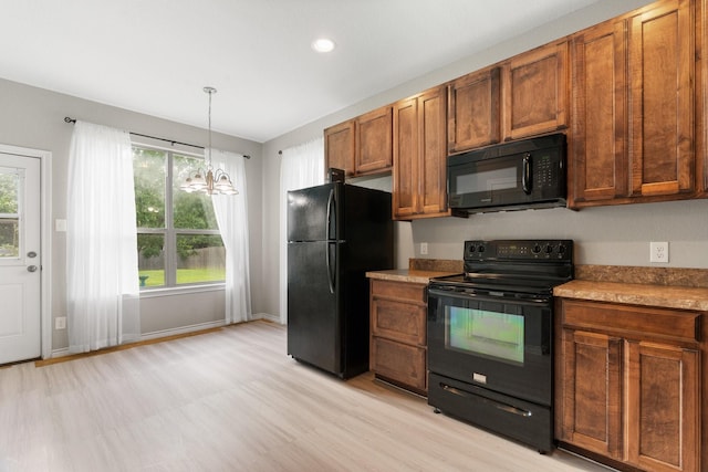 305 S 1st St, Grandview, TX 76050 - kitchen featuring a chandelier, brown cabinetry, baseboards, pendant lighting, and black appliances