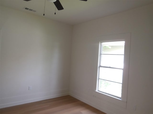unfurnished room with plenty of natural light, visible vents, ceiling fan, and light wood-type flooring