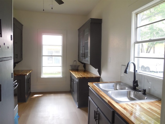 kitchen featuring a sink, butcher block counters, and plenty of natural light