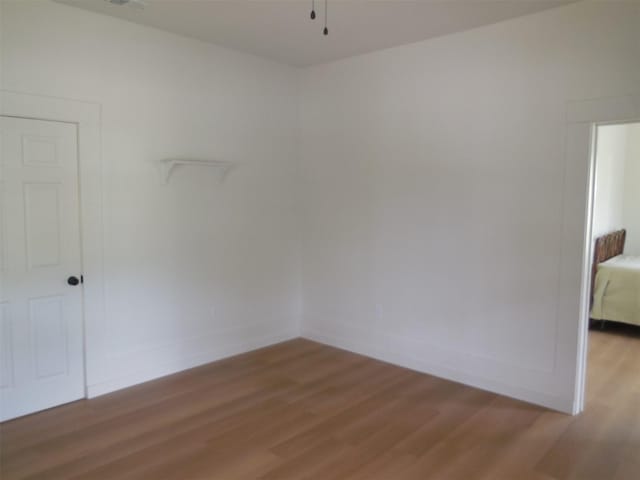 spare room with baseboards and light wood-style floors