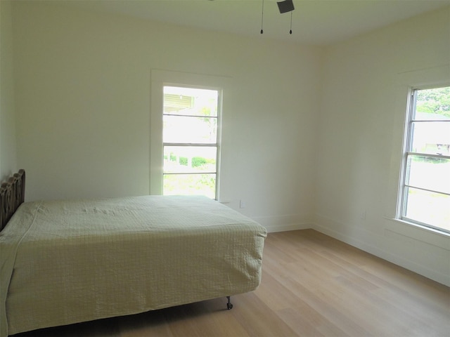 bedroom featuring light wood finished floors, ceiling fan, and baseboards