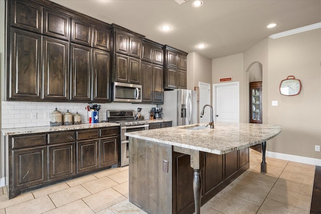 4339 Paige Dr, Caddo Mills, TX 75135 - kitchen with light tile patterned floors, decorative backsplash, a sink, stainless steel appliances, and arched walkways
