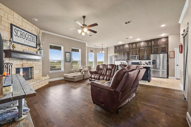 4339 Paige Dr, Caddo Mills, TX 75135 - living area featuring a barn door, ornamental molding, ceiling fan, a stone fireplace, and visible vents