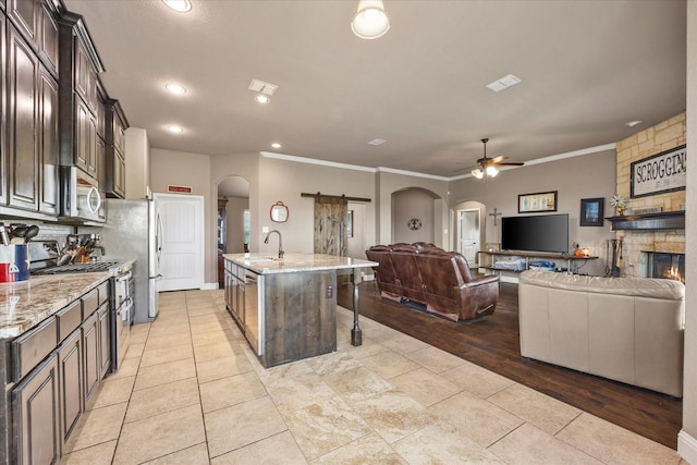 4339 Paige Dr, Caddo Mills, TX 75135 - kitchen featuring arched walkways, a sink, open floor plan, and stainless steel appliances