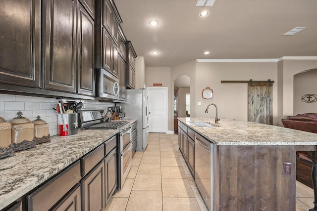 4339 Paige Dr, Caddo Mills, TX 75135 - kitchen with arched walkways, decorative backsplash, appliances with stainless steel finishes, a sink, and visible vents