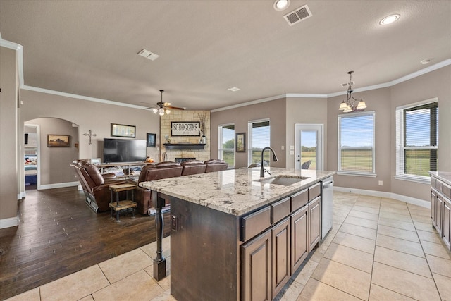 4339 Paige Dr, Caddo Mills, TX 75135 - kitchen featuring arched walkways, stainless steel dishwasher, a sink, a ceiling fan, and light tile patterned flooring