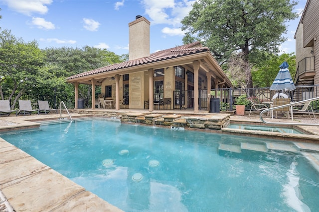view of pool with fence, a ceiling fan, a patio, a pool with connected hot tub, and cooling unit