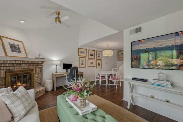 living room with lofted ceiling, visible vents, a fireplace, wood finished floors, and a ceiling fan