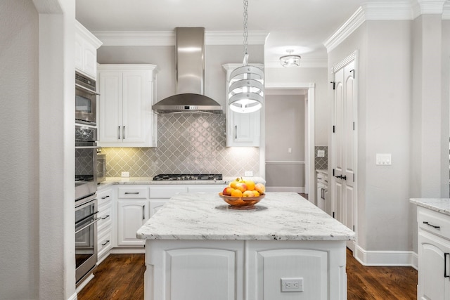 kitchen featuring wall chimney exhaust hood, backsplash, ornamental molding, white cabinets, and appliances with stainless steel finishes